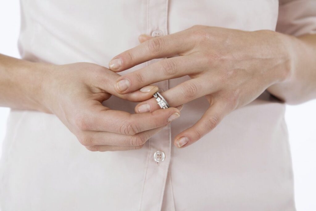 женщина снимает с пальца кольцо